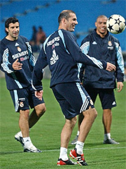 Zidane domina el balón,  anoche, en la sesión preparatoria del Madrid, junto a Figo y Ronaldo.