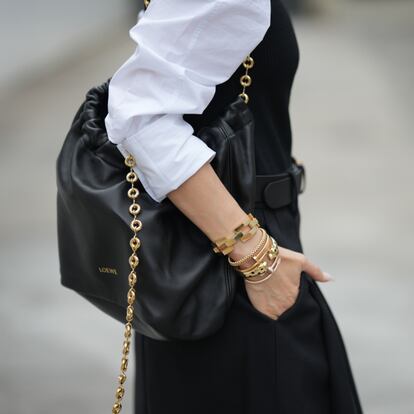 Una mujer con la mano llena de pulseras metida en el bolsillo.