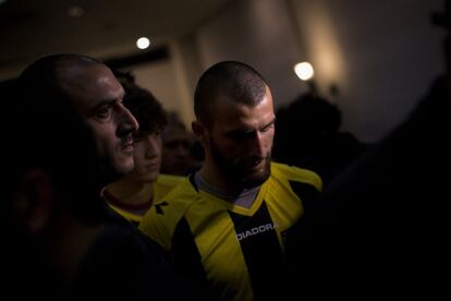 In this Wednesday, Jan. 30, 2013 photo, new Beitar Jerusalem F.C. soccer players Zaur Sadayev, center, and Gabriel Kadiev, background, leave at the end of a press conference in Jerusalem. Beitar has long tried to quell a tight-knit group that calls itself "La Familia" and whose behavior has had the team docked points and forced it to play before empty stadiums. The group is routinely abusive toward opposing players, taunting them with racist and anti-Arab chants. (AP Photo/Bernat Armangue)