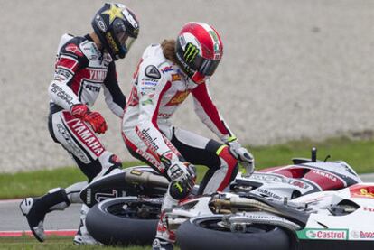 Simoncelli, en primer término, y Lorenzo corren a levantar sus motos tras la caída provocada por el piloto italiano en su intento de adelantamiento.