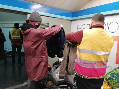 Los voluntarios organizan la ropa donada para entregársela a las personas sin hogar en la Estación del Arte. I.U