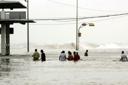 Vecinos de La Habana caminan por el Malecón, completamente cubierto de agua.