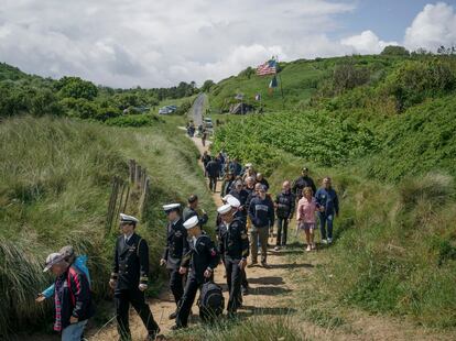 Miembros del ejército estadounidenses y visitantes caminan hacia la playa de Omaha, tras la ceremonia de inauguración de un nuevo monumento a los soldados de la Navy en Saint-Laurent-sur-mer.