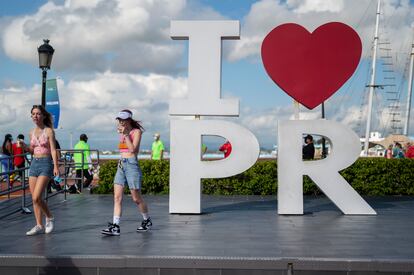 Tourists walk through the docking area after exiting Carnival's Mardi Gras cruise ship in the bay of San Juan, Puerto Rico, on Aug. 3, 2021.