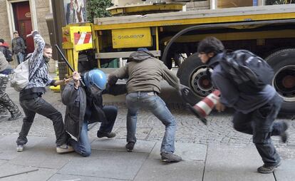 Un grupo de manifestantes golpea a un policía durante la protesta en Turín.