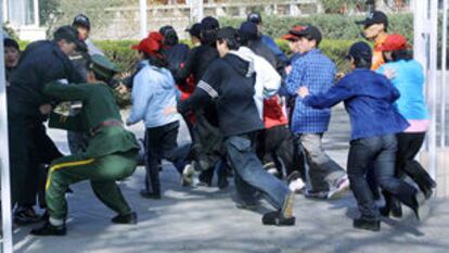 Un policía chino trata de impedir la entrada del grupo de norcoreanos a la embajada española.