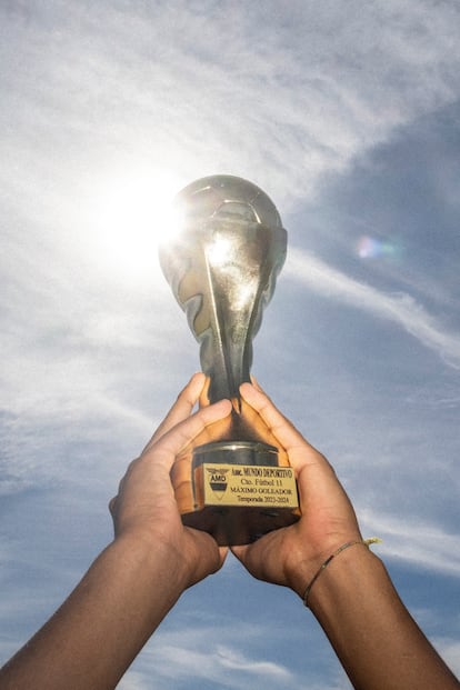 
Dylan levanta el trofeo pichichi logrado en la liga Mundo Deportivo. 
