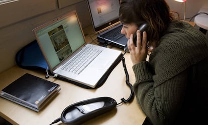 Una mujer habla desde el teléfono fijo.