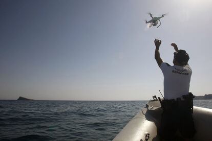 Un agente de la Policía Local alza el vuelo del dron en la costa de Benidorm.