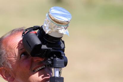 Un hombre contempla el eclipse a través de una cámara de fotos, en la isla del Océano Índico de La Reunión.