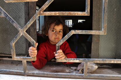 Una niña siria desplazada mira a través de una ventana mientras espera con su familia en una mezquita en la ciudad de Hasaka, al noreste de Siria. Este país es el que más ayuda humanitaria recibió en 2020.