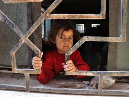 Una niña siria desplazada mira a través de una ventana mientras espera con su familia en una mezquita en la ciudad de Hasaka, al noreste de Siria. Este país es el que más ayuda humanitaria recibió en 2020.