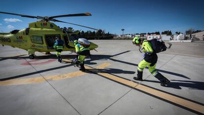 Tres sanitarios se dirigen a un helicóptero del Summa 112 en la base de Las Rozas.