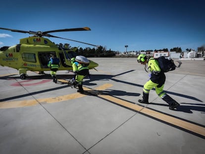 Tres sanitarios se dirigen a un helicóptero del Summa 112 en la base de Las Rozas.