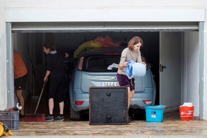 Una familia limpia los destrozos causados por el temporal en su vivienda en Alcocéber (Castellón).