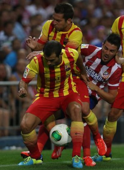 Mascherano protege el bal&oacute;n ante Jordi Alba y Villa.