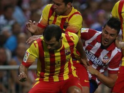 Mascherano protege el bal&oacute;n ante Jordi Alba y Villa.