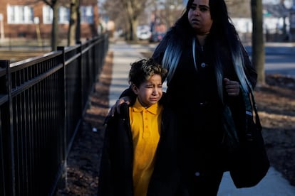 Un niño de 8 años llora mientras se acerca a la escuela primaria Wentworth con su madre, Angélica Beltrán, en febrero de 2024