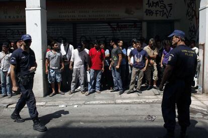 La policía detiene a un grupo de inmigrantes el domingo en el centro de Atenas.