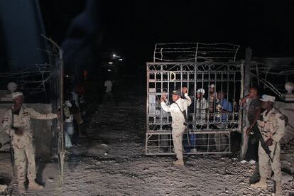 Un grupo de soldados dominicanos vigilan la verja que controla el paso fronterizo de Jimaní, entre República Dominicana y Haití.