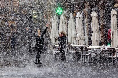 Dos personas entre la nieve en una calle de Teruel. 