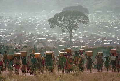 En cuanto se corrió la voz de la muerte del presidente Juvenal Habyarimana, los hutus comenzaron a matar a tutsis y miembros moderados de su propia etnia: hombres, mujeres, niños y ancianos fueron masacrados a tiros y machetazos. En la imagen, desplazados ruandeses, que huían del baño de sangre, transportan contenedores de agua a sus chozas en el campamento de refugiados de Benaco en Tanzania, cerca de la frontera con Ruanda, el 17 de mayo de 1994.