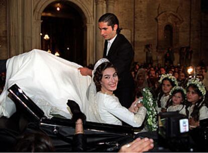 Los novios se suben en un coche de caballos en la puerta de la iglesia.