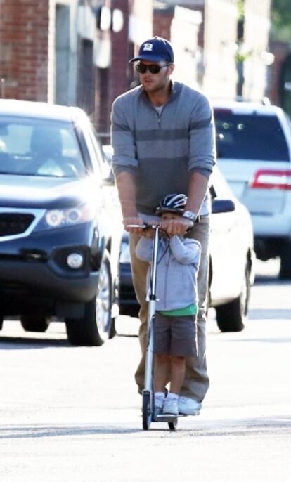 El jugador de fútbol americano Tom Brady y su hijo Benjamin montando en patinete por las calles de Boston.