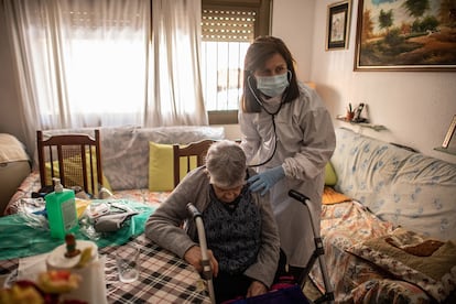 Una doctora atiende una anciana durante una visita domiciliaria en Les Roquetes del Garraf, Barcelona.