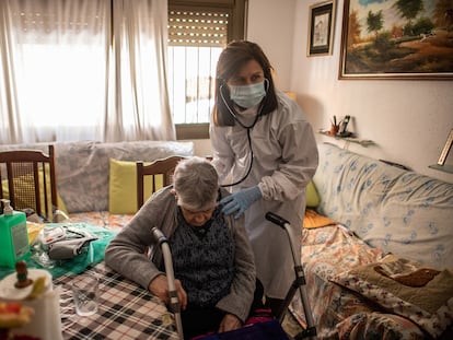 Una doctora atiende una anciana durante una visita domiciliaria en Les Roquetes del Garraf, Barcelona.