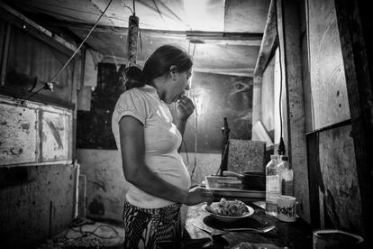 Las chabolas no cuentan con ningún servicio básico como agua, luz o gas, por lo que sus pobladores se enganchan al alumbrado público. En la foto, una mujer embarazada prepara la cena.