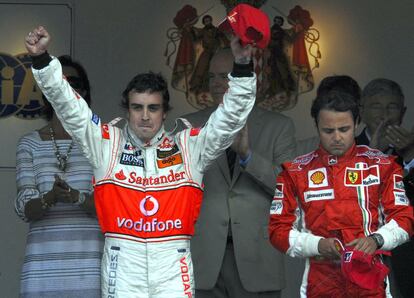El piloto español Fernando Alonso, a la izquierda, levanta los brazos junto a Felipe Massa, durante la ceremonia de entrega de trofeos del Gran Premio de Fórmula 1 de Montecarlo, en 2007.