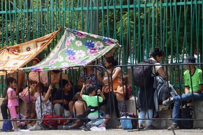 Un grupo de migrantes se resguarda del sol y del calor junto a las oficinas del Inami, el 5 de mayo.