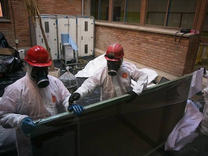 Trabajadores retiran una de las pizarras con amianto en un colegio de Cataluña. 