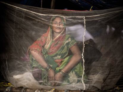 Pooja Raidas, de 28 años, embarazada de nueve meses, se sienta bajo una red antimosquitos en una tienda improvisada frente a su casa dañada por las inundaciones en el oeste de Nepal. Agosto de 2017.