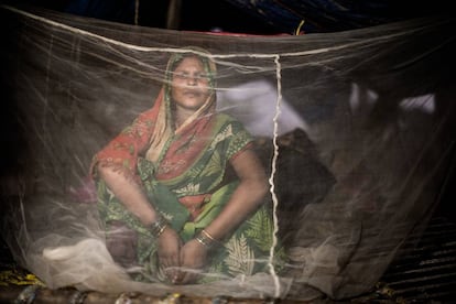 Pooja Raidas, de 28 años, embarazada de nueve meses, se sienta bajo una red antimosquitos en una tienda improvisada frente a su casa dañada por las inundaciones en el oeste de Nepal. Agosto de 2017.