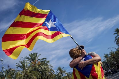 Dos manifestantes se abrazan durante la concentración convocada esta tarde en apoyo a la declaración unilateral de independencia, en el Paseo de Lluis Companys, frente al parque de la Ciutadella de Barcelona.