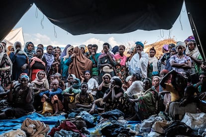 Un grupo de personas desplazadas que huyen de la violencia en la zona de Metekel, al oeste de Etiopía, se reúnen fuera de una carpa donde se distribuye ropa en un campamento en Chagni, Etiopía el pasado 26 de enero de 2021.