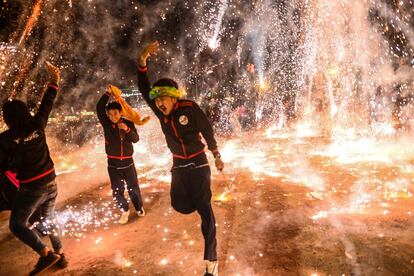 Un grupo de personas celebran con fuegos artificiales el Festival de Iluminación de Tazaungdaing (Myanmar).