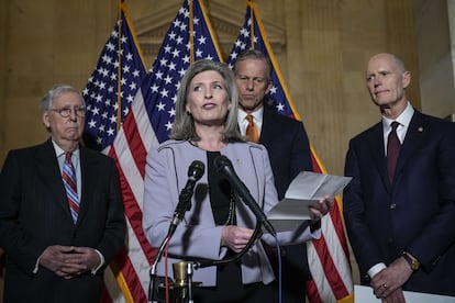 Mitch McConnell (izquierda) y Rick Scott (derecha) escuchan hablar a la senadora republicana Joni Ernst, en presencia del también senador John Thune.