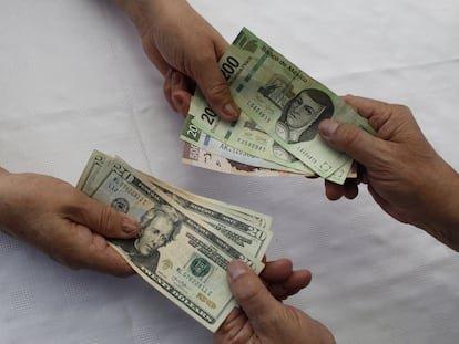 Una persona intercambia dólares por pesos mexicanos.
