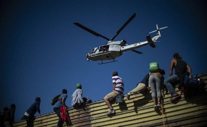 Un grupo de migrantes centroamericanos, en su mayoría hondureños, trepan la frontera entre México y Estados Unidos, cerca del cruce de El Chaparral, en Tijuana.