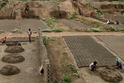 Trabajadores indios preparan el barro para fabricar ladrillos, en Pampore, cerca de Srinagar, una de las zonas áridas del país.