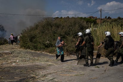 Una mujer refugiada huye con su bebé de las llamas cerca de Mitilene, capital de Lesbos.