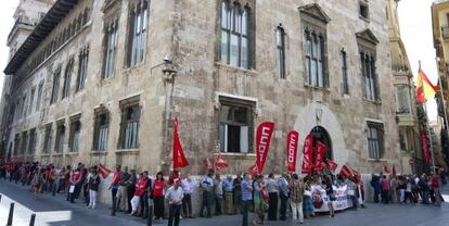 Sindicalistas de CC OO, UGT CSIF y representantes del PSPV, Comprom&iacute;s y EUPV `abrazan&acute; el Palau de la Generalitat.