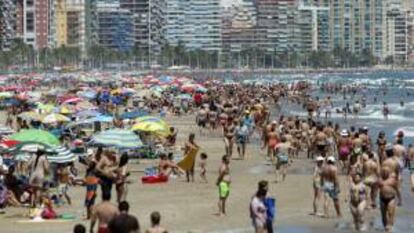 Veraneantes disfrutan al pie de los apartamentos de la playa de Cullera, en Valencia. EFE/Archivo