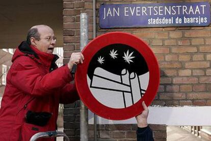 Un empleado coloca señales de prohibición de fumar drogas en la calle en el barrio de De Baarsjes de Amsterdam.