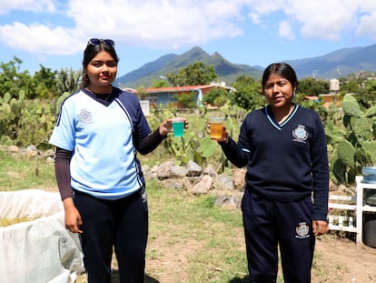 Shanni y Rosa muestran el agua entintada que colectan