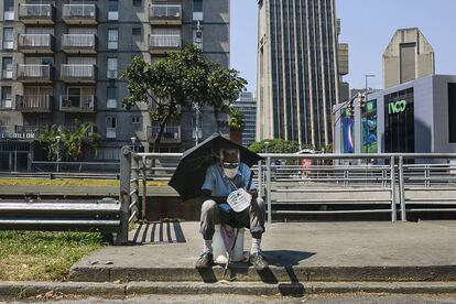 Un hombre pide limosna sentado en la avenida Libertador de la capital de Venezuela.