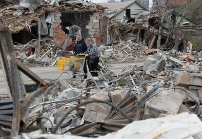 Dos civiles caminan entre edificios destruidos en Mariupol, este martes.
